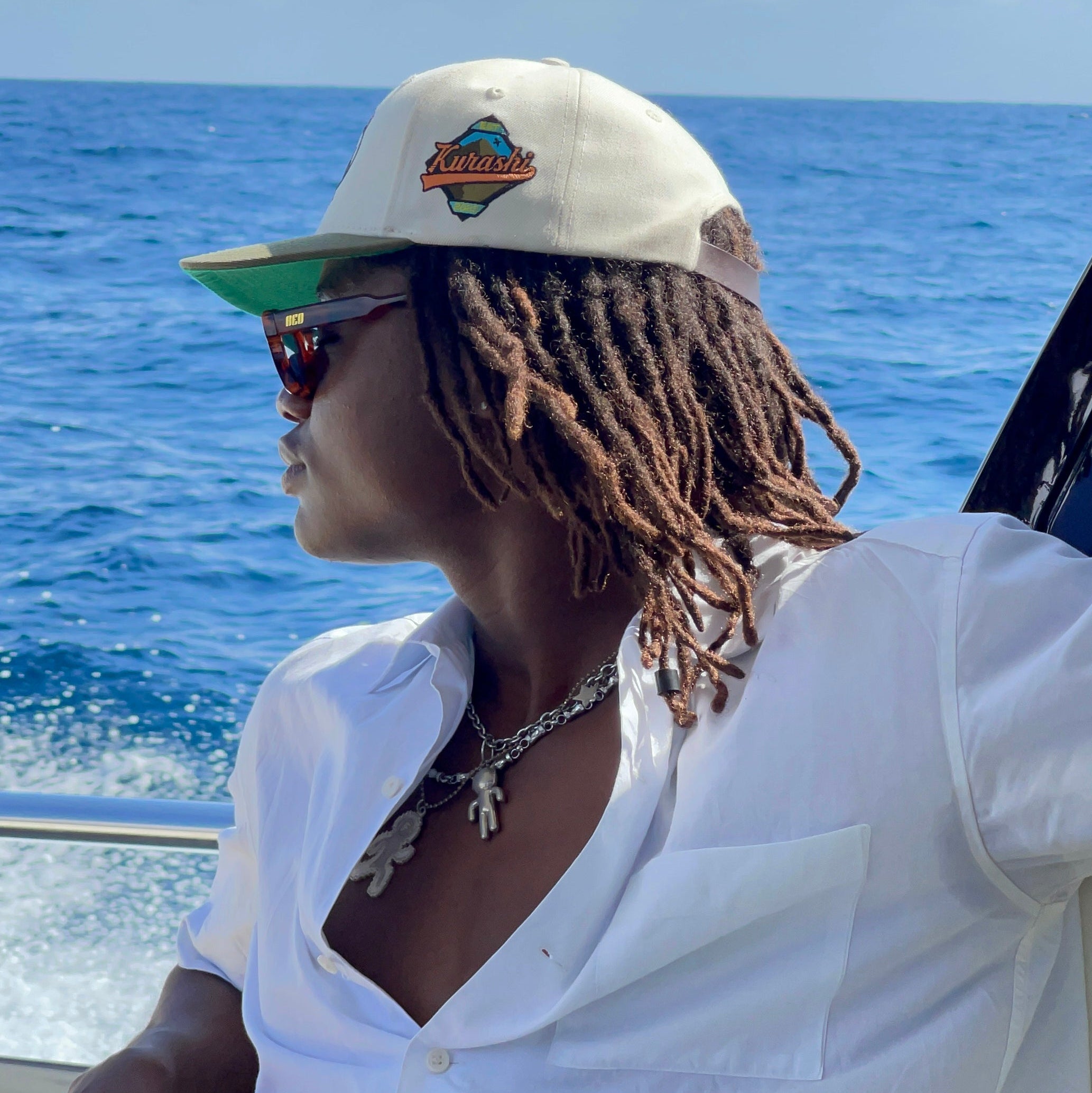 Person wearing reo retro frame sunglasses with a clear blue sky in the background