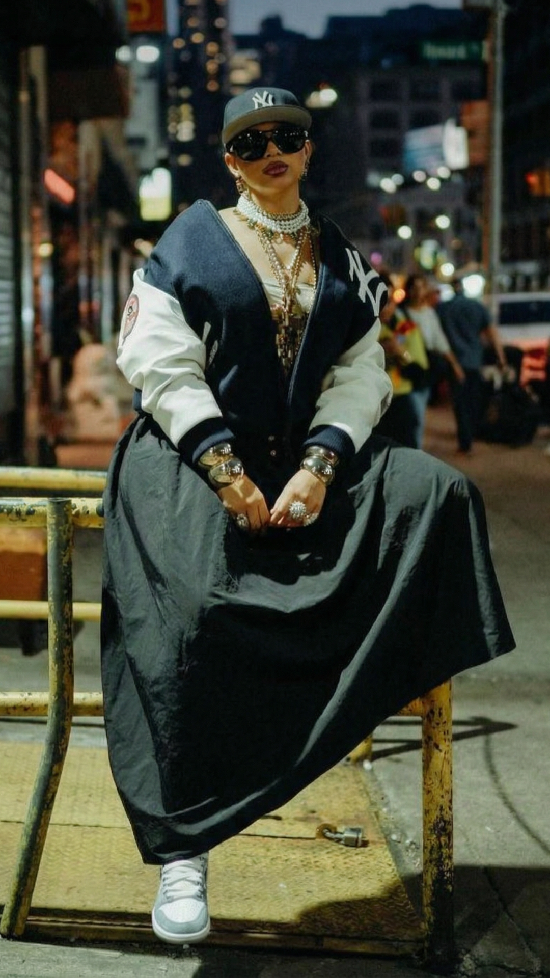 Person sitting on a bench in an urban setting at night